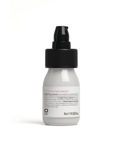White bottle of face serum with black cap on a white background
