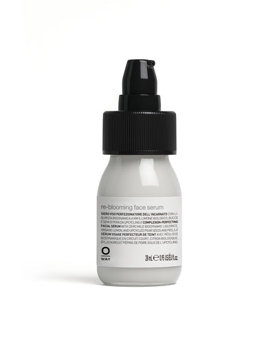 White bottle of re-blooming face serum with black cap on a white background